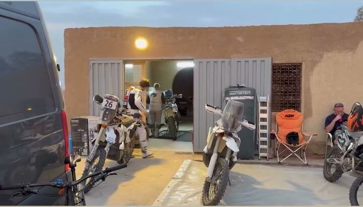 Rally bikes outside the garage of the RTC base in Morocco at dawn, before a roadbook session
