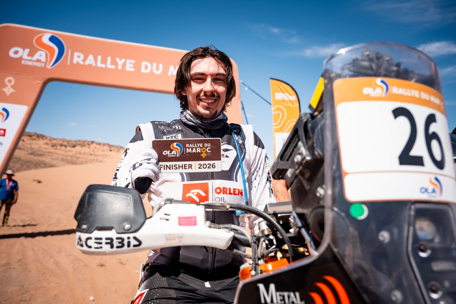 Konrad Dąbrowski z kartą finishera pod bramą Rallye du Maroc