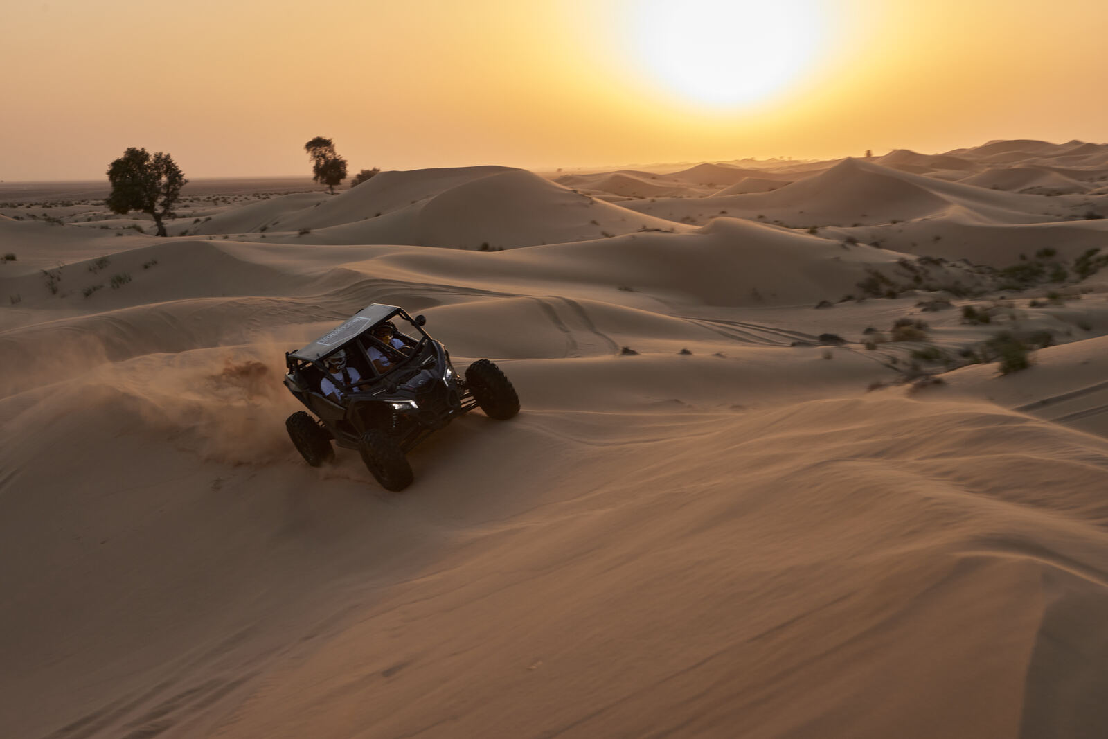 A Can-Am Maverick crossing the Al Qudra dunes at sunset, frame 2 of eight