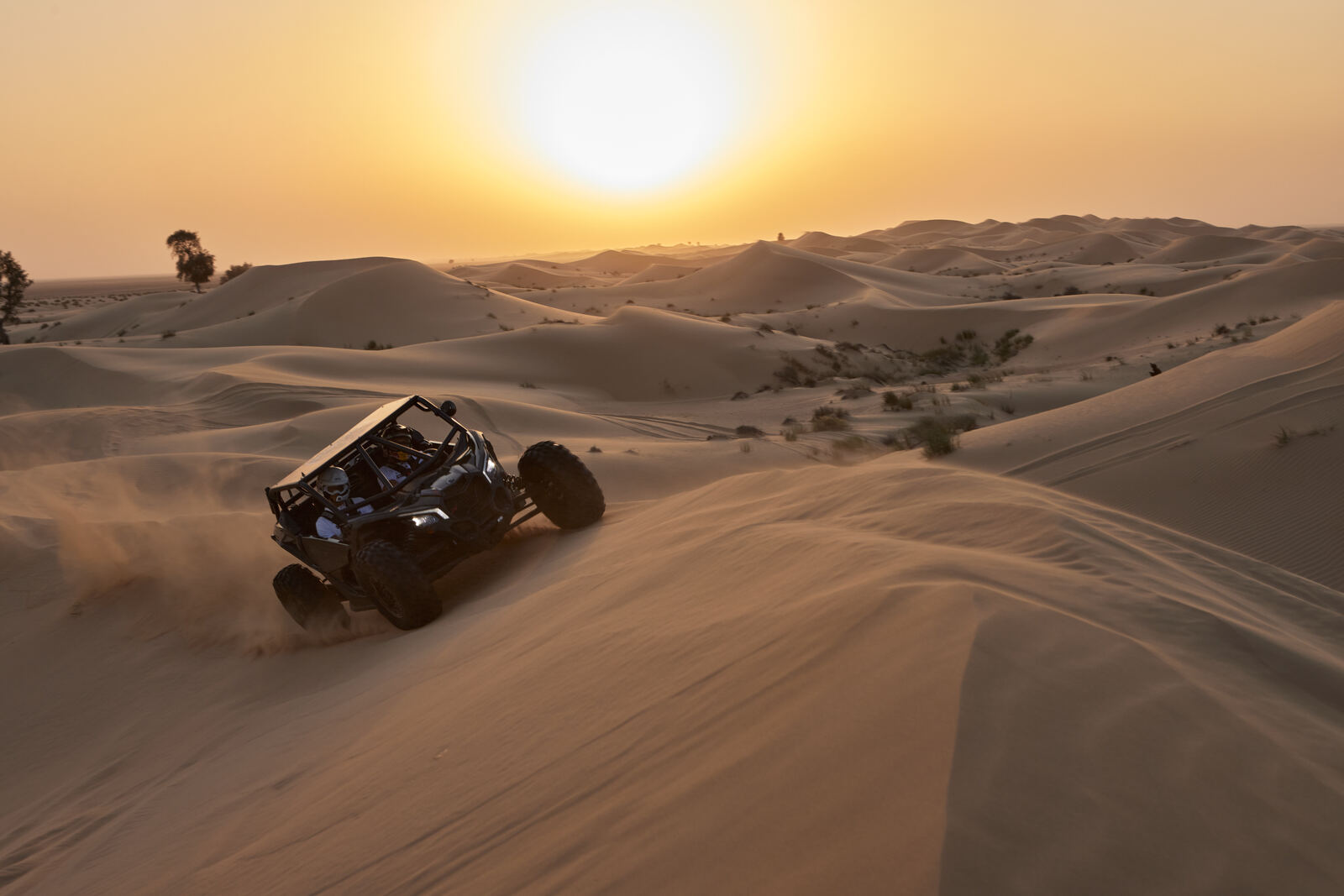 A Can-Am Maverick crossing the Al Qudra dunes at sunset, frame 3 of eight