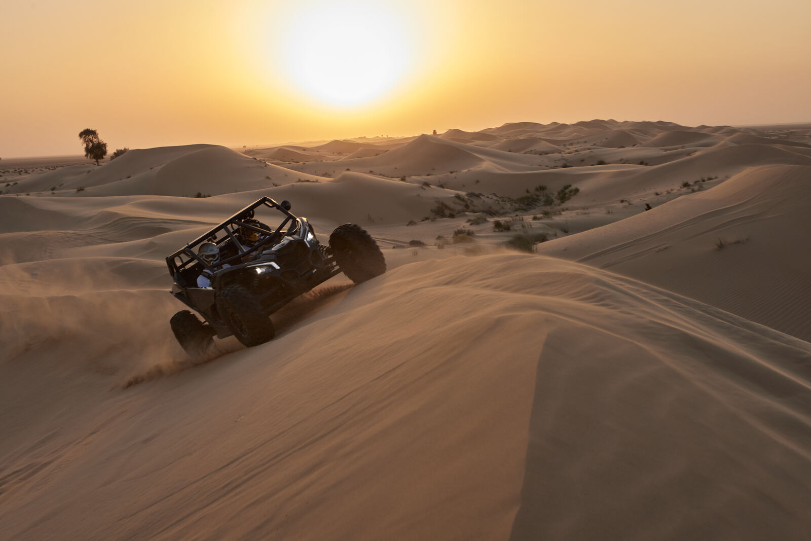 A Can-Am Maverick crossing the Al Qudra dunes at sunset, frame 4 of eight