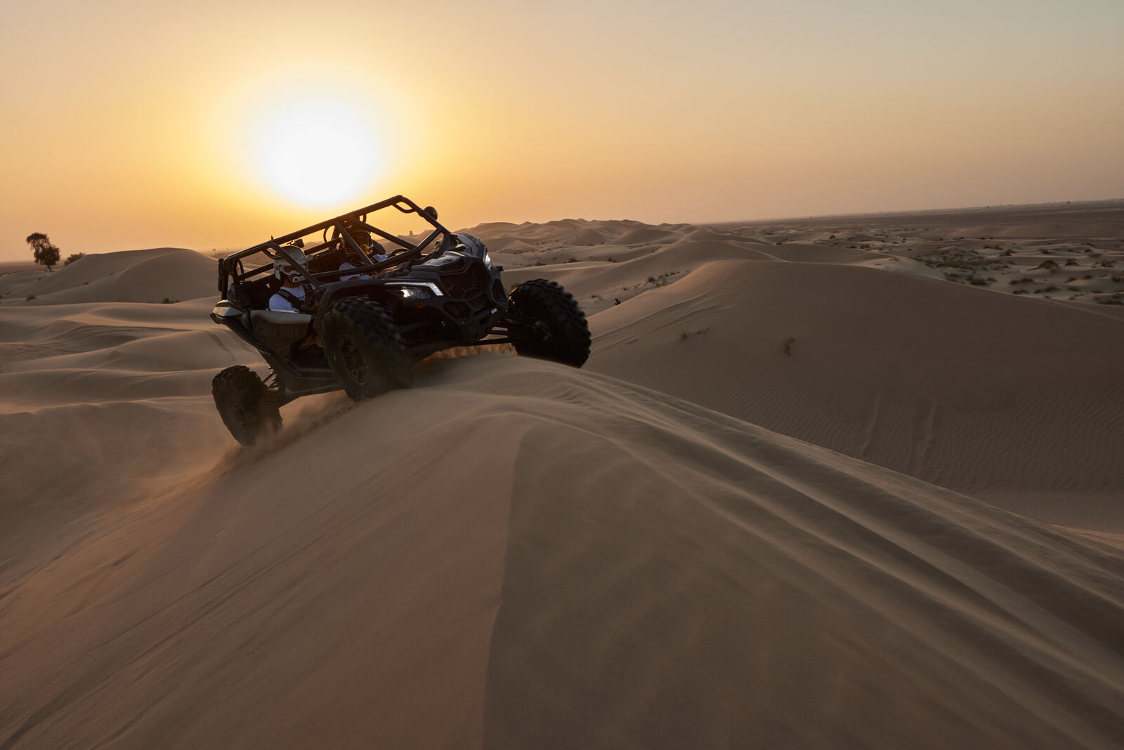 A Can-Am Maverick crossing the Al Qudra dunes at sunset, frame 5 of eight