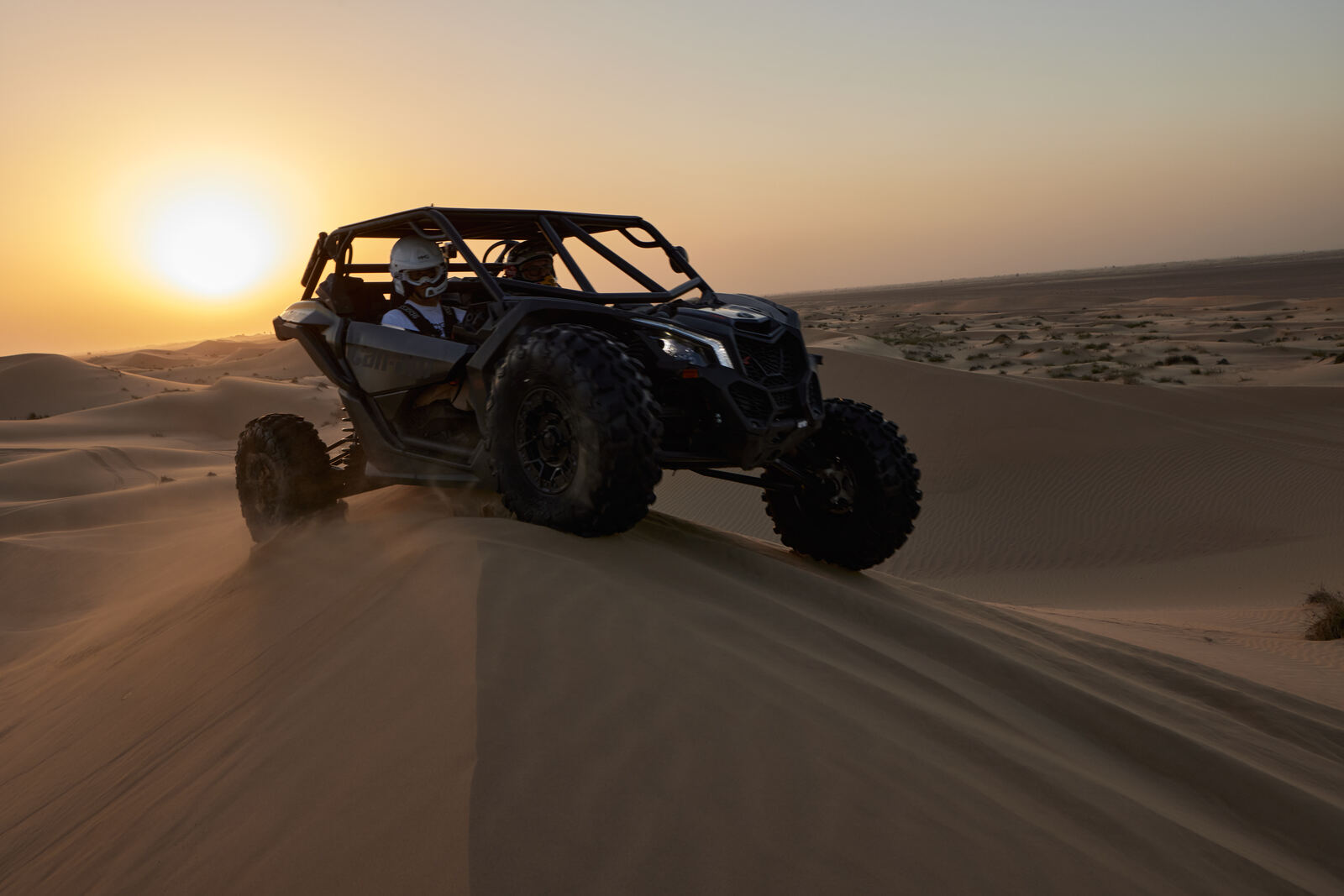 A Can-Am Maverick crossing the Al Qudra dunes at sunset, frame 6 of eight