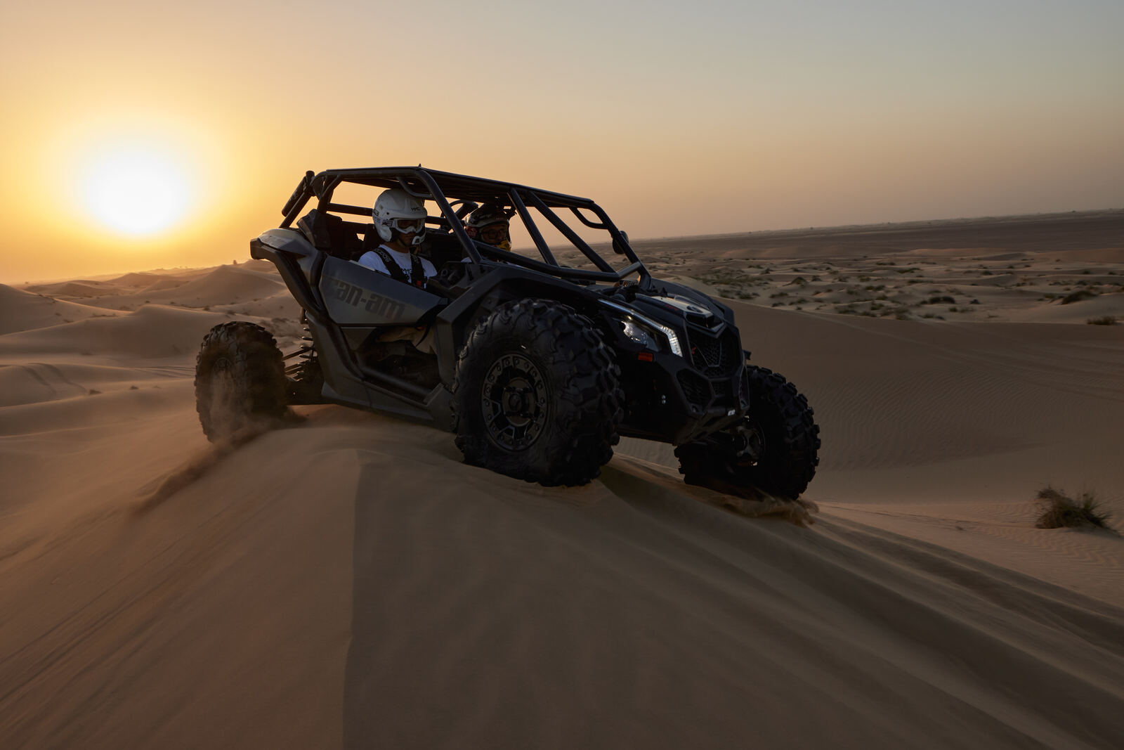 A Can-Am Maverick crossing the Al Qudra dunes at sunset, frame 7 of eight