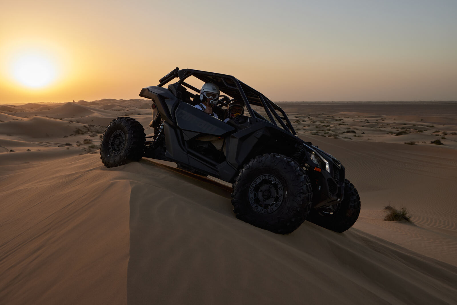A Can-Am Maverick crossing the Al Qudra dunes at sunset, frame 8 of eight